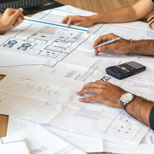 professionals sitting over a table with plans